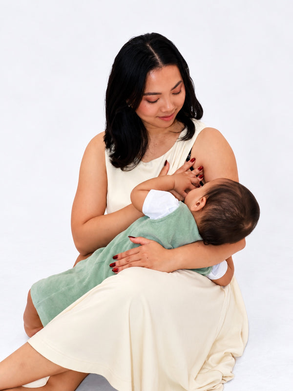 Mum breastfeeding from the side opening of the Butter dress, tummy covered